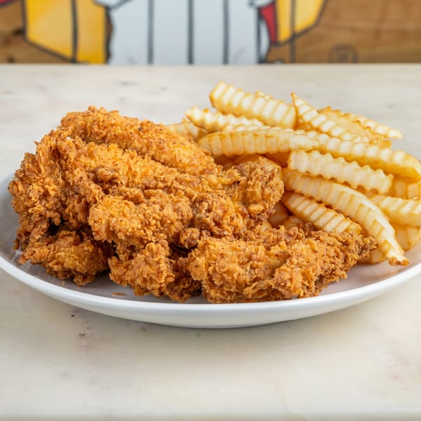 Crispy fried chicken tenders and crinkle-cut fries on a white plate.